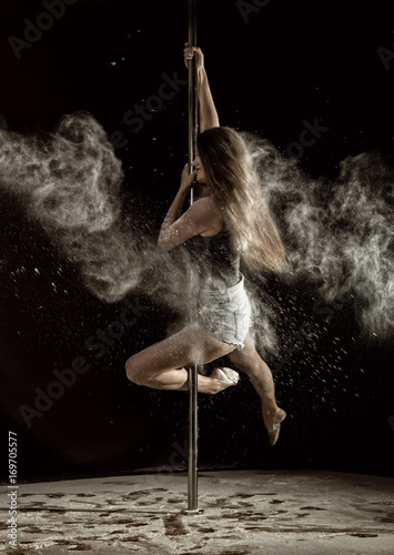 Beautiful expressive dencer dancing at studio with flour photo