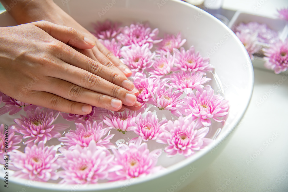 Fototapeta premium Spa treatment and product for female feet and manicure nails spa with pink flower, copy space, soft and select focus, Thailand. Healthy Concept.