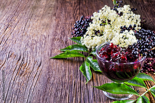 Toasts with elderberry jam and fresh berry fruits on wooden table. Free space for your text.
