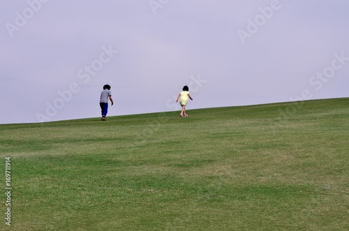広い芝生の公園を走る子供たち © goro20