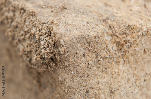 Packed sand with focus on a group of loose grains.