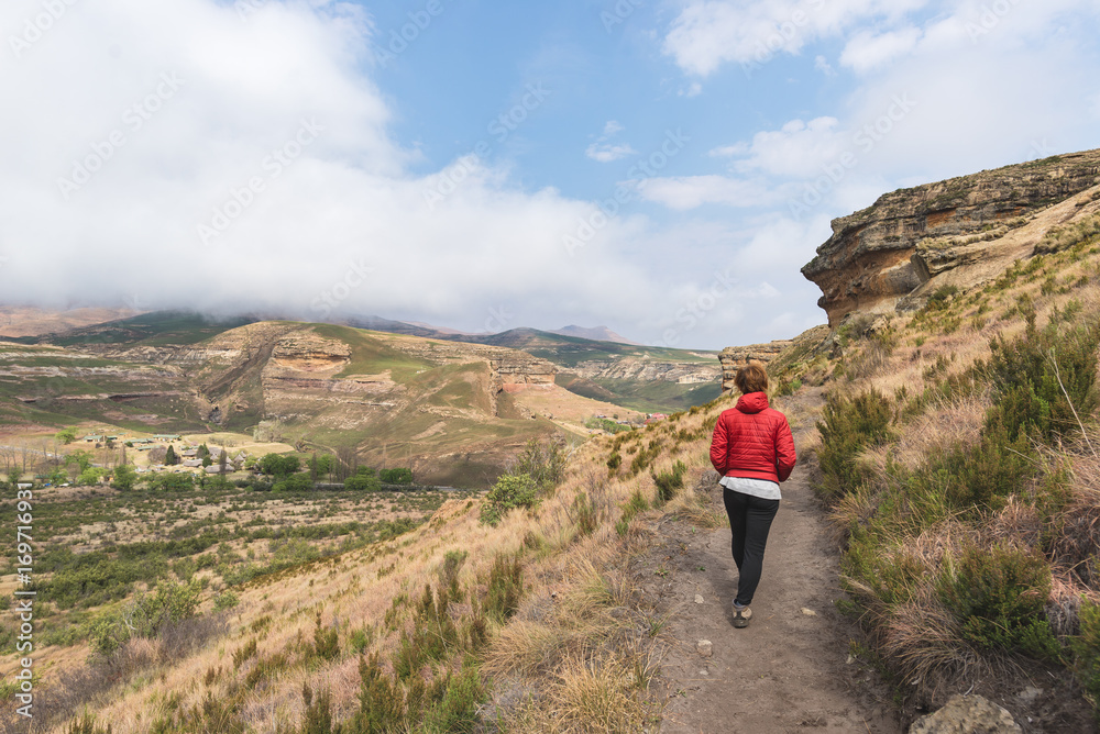 Tourist trekking on marked trail in the Golden Gate Highlands National Park, South Africa. Scenic table mountains, canyons and cliffs. Adventure and exploration in Africa.