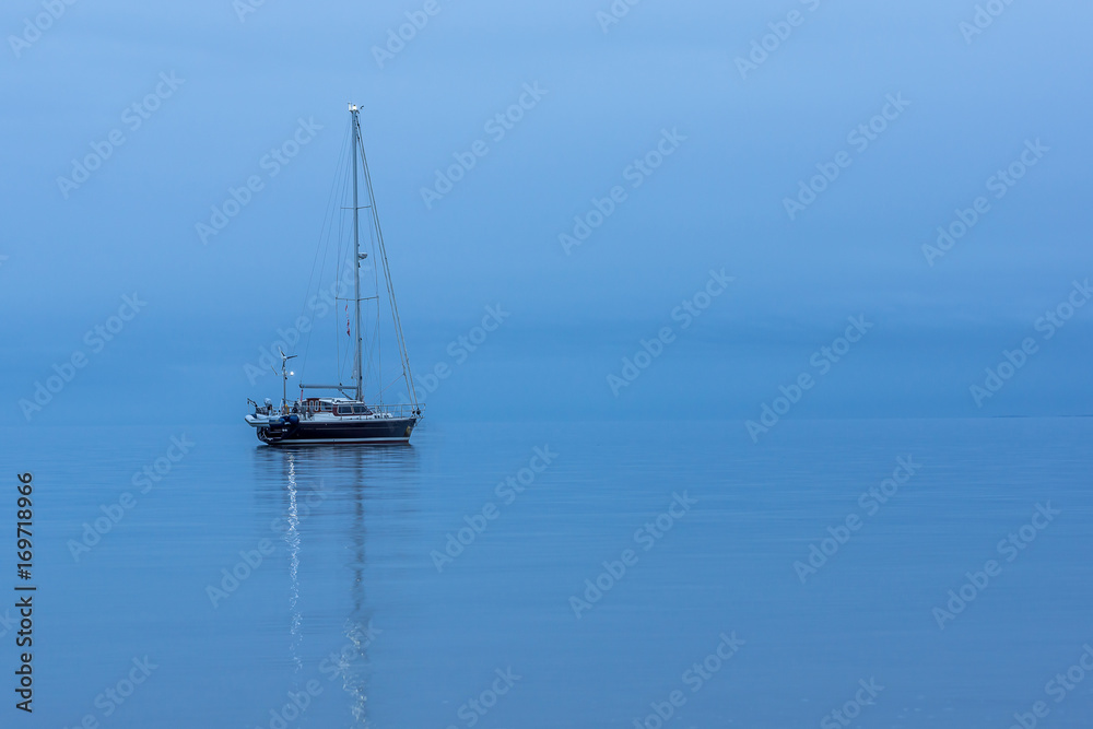 Sailing boat alone in the ocean durig blue hour. HDR-Photo