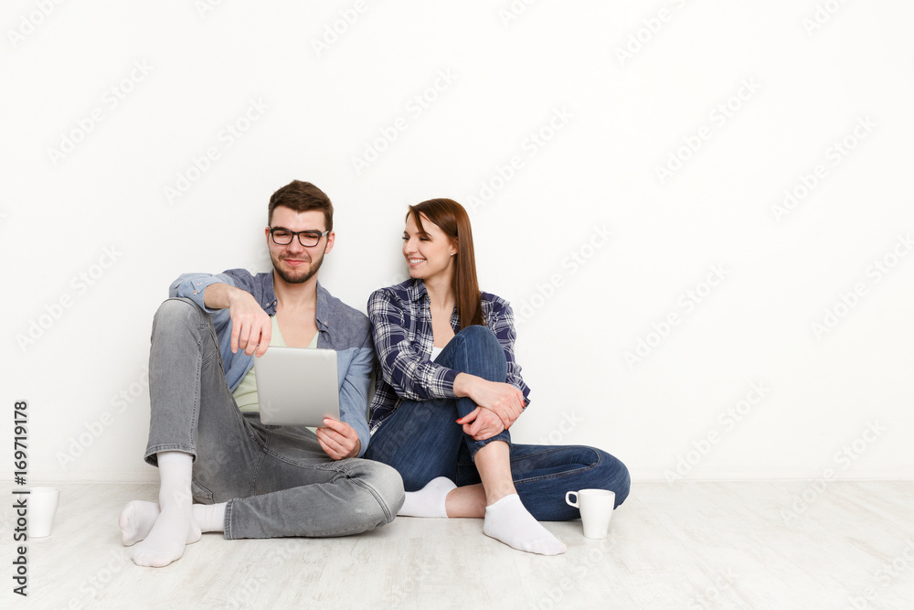Smiling couple web-surfing on tablet, studio shot Smiling couple web-surfing on tablet, studio shot