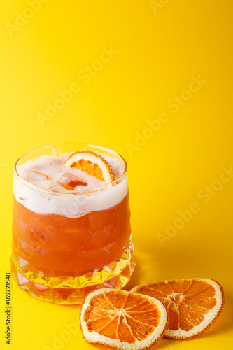Orange cocktail with citron on colorful background