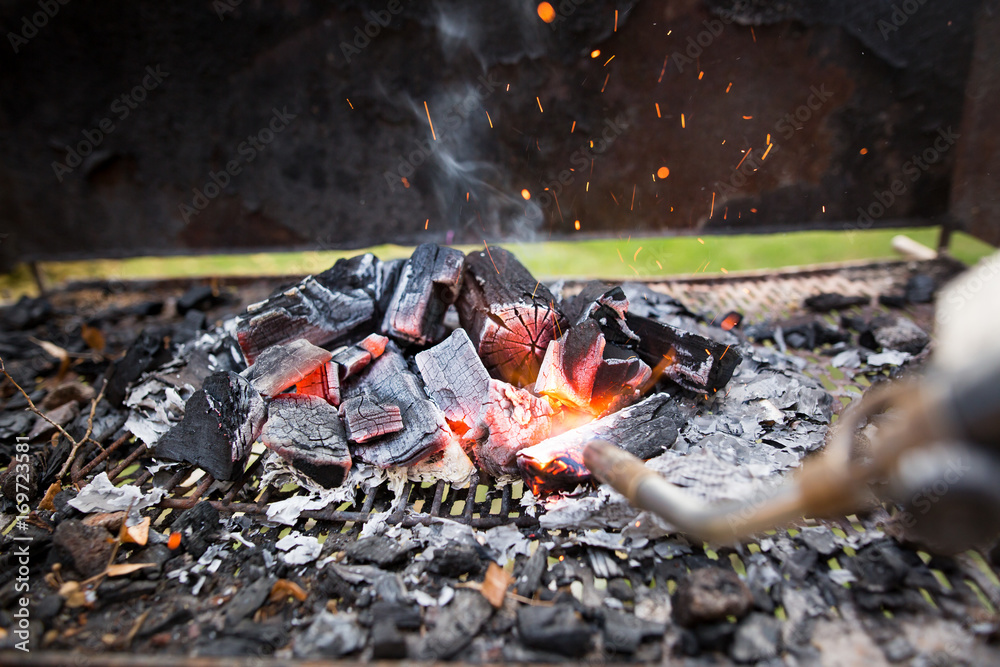 BBQ Grill Pit With Glowing And Flaming Hot Charcoal Briquettes, Food Background Or Texture, Close-Up BBQ Grill Pit With Glowing And Flaming Hot Charcoal Briquettes, Food Background Or Texture, Close-Up