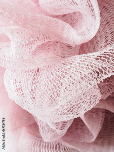 Pink plastic loofa hygine scrubber covered of water drops