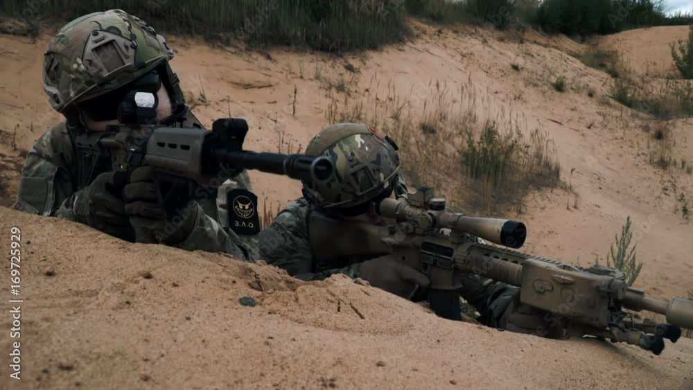 Soldiers with sniper rifle lying on sand front view. Soldiers with weapons Soldiers with sniper rifle lying on sand front view. Soldiers with weapons