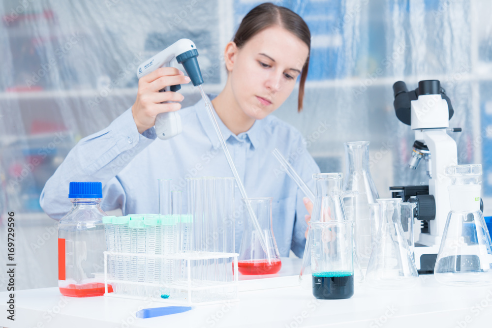 Fototapeta premium Woman Scientist Adding Liquid To Test Tube With Pipette In Lab