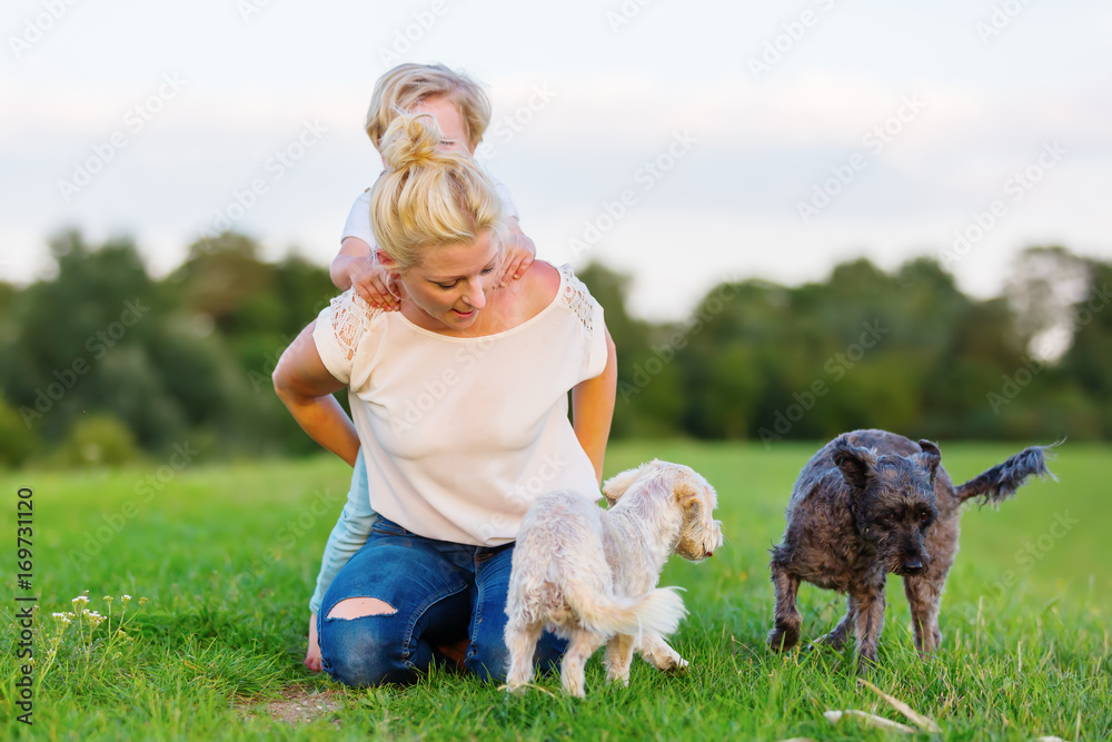 woman plays with her son and two small dogs