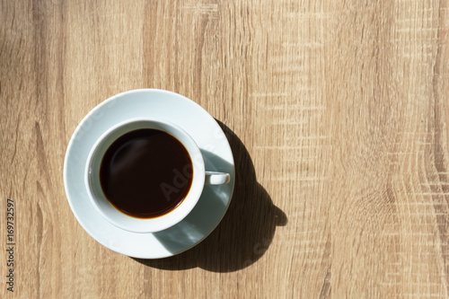 top view. espresso coffee in white cup on wooden table in sunny day.