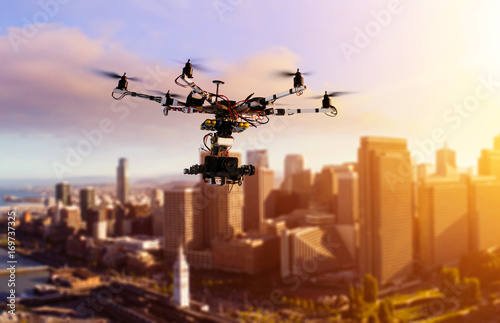Drone Flying over San-Francisco city. Hexacopter drone with high resolution digital camera on the sky. Heavy lift drone photographing city at sunset. Toned photo with blurred background.
