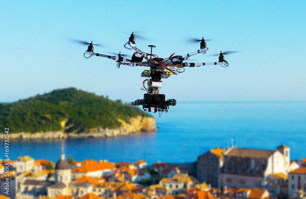 Professional heavy drone with a cinema camera flying above the old city at summer day. Croatia, Dubrovnik. Blurred background. Professional heavy drone with a cinema camera flying above the old city at summer day. Croatia, Dubrovnik. Blurred background.