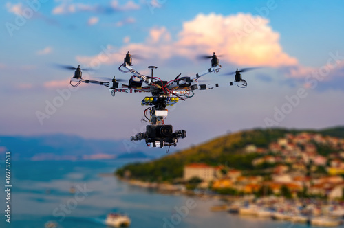 Fototapeta Naklejka Na Ścianę i Meble -  The drone with the professional cinema camera flying over the old town at the sunset. Trogir, Croatia. Blurred background.