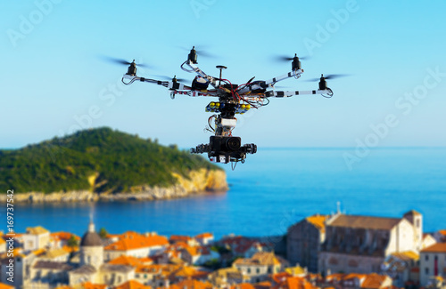 Professional heavy drone with a cinema camera flying above the old city at summer day. Croatia, Dubrovnik. Blurred background.