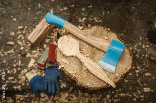 Overhead view of axe and shaved wood on stump photo