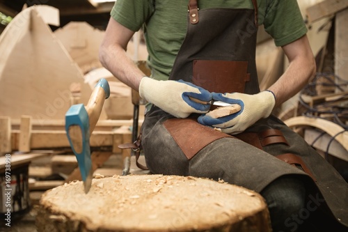 Carpenter shaping wood with worktool photo