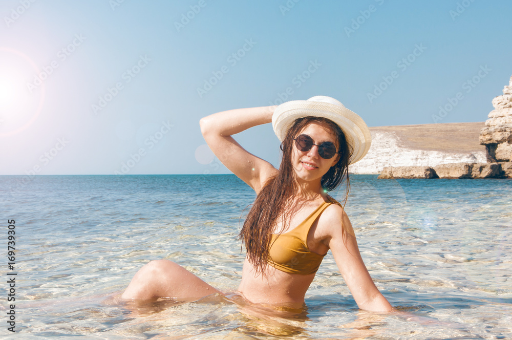 Beautiful girl in bikini, glasses and hat in clear sea water Beautiful girl in bikini, glasses and hat in clear sea water