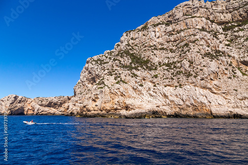 Sardinia, Italy. A picturesque rocky coast near cape Capo Caccia and a boat