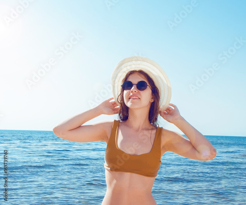 Beautiful girl in bikini, glasses and hat in clear sea water © Subtropicals