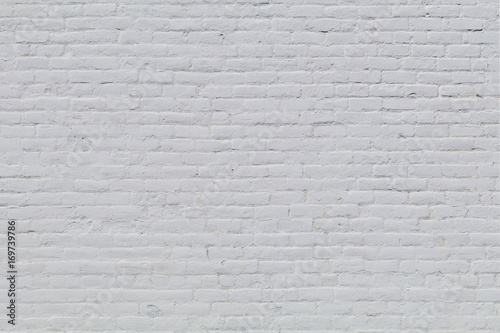 Solid old brick wall with white paint