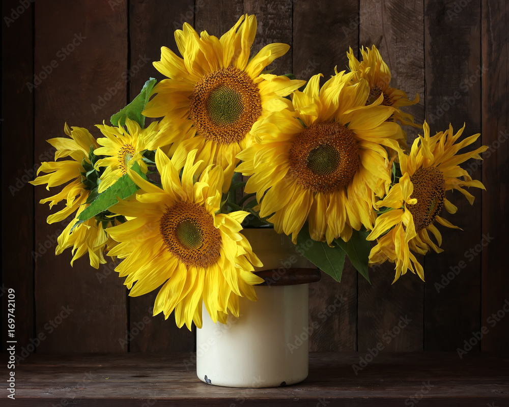 Fototapeta premium Bouquet of sunflowers in a can on a dark background.