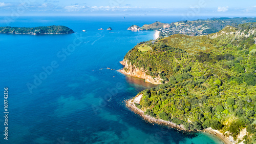 Aerial view on sunny beach with residential suburb on the background. Coromandel Peninsula, New Zealand.
