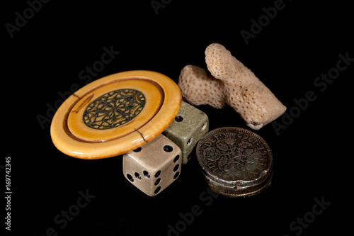 Vintage lucky charms. Antique poker chip, dice, squashed sixpences and coral. photo