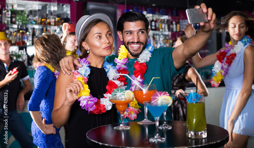 Couple making selfie with cocktails
