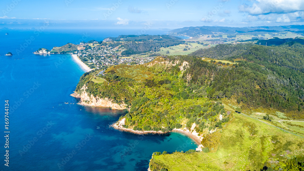 Aerial view on sunny beach with residential suburb on the background. Coromandel Peninsula, New Zealand.