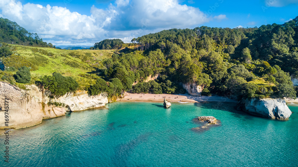 Fototapeta premium Aerial view on a remote ocean coast with small coves and mountains on the background. Coromandel, New Zealand.
