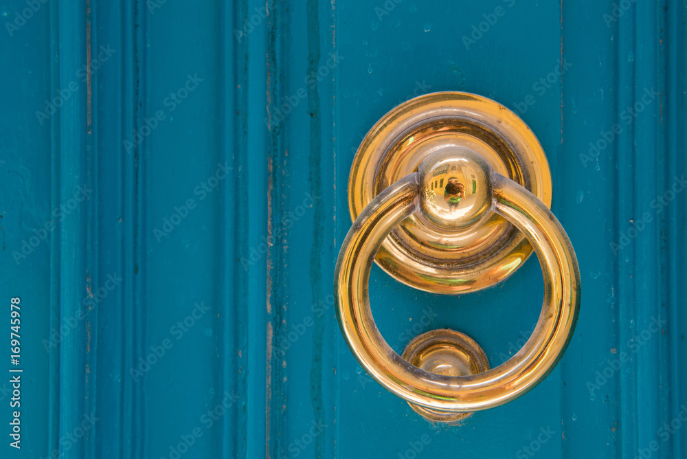 Obraz premium Golden door knocker on a blue wooden door