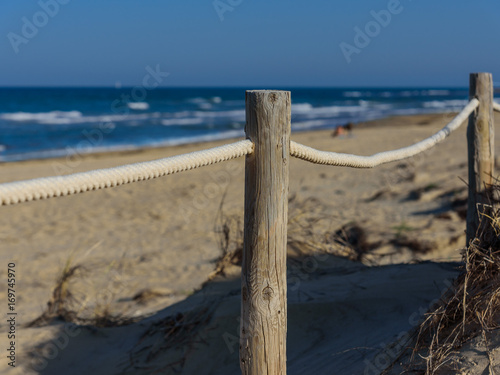 Rope fence on the sandy beach of La Mata. Sunset on the beach. Blurred unfocused background 01