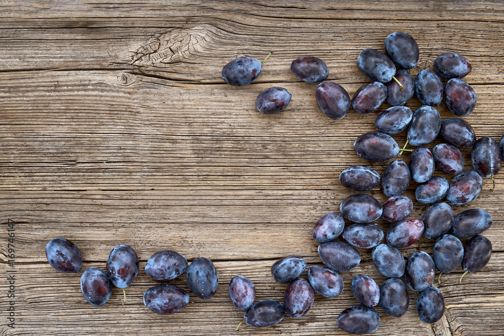 Fresh blue plums on old wooden table. Organic food. Top view, copy space. Fresh blue plums on old wooden table. Organic food. Top view, copy space.