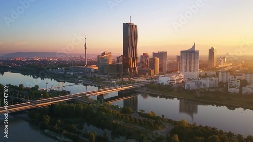aerial view of vienna skyscrapers modern city at sunrise flying over danube bridge