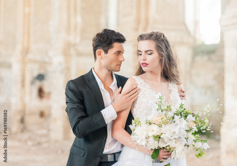 Bride and groom at wedding ceremony by the old cathedral Bride and groom at wedding ceremony by the old cathedral