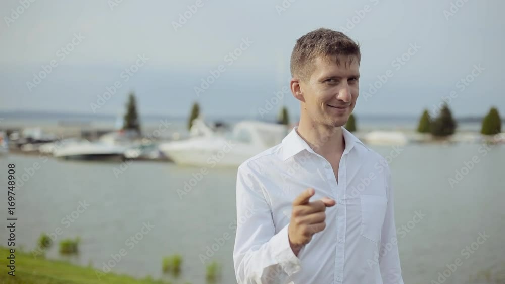 Handsome young man on the coast pointing on you and looking at the camera Handsome young man on the coast pointing on you and looking at the camera