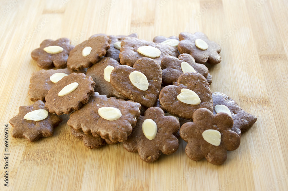 Brown moravian dark gingerbreads with sliced almonds on wooden table, christmas cookies, Variety of shapes Brown moravian dark gingerbreads with sliced almonds on wooden table, christmas cookies, Variety of shapes