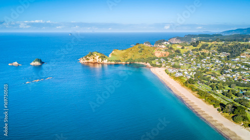 Aerial view on small suburb on a sunny ocean beach. Coromandel peninsula  New Zealand