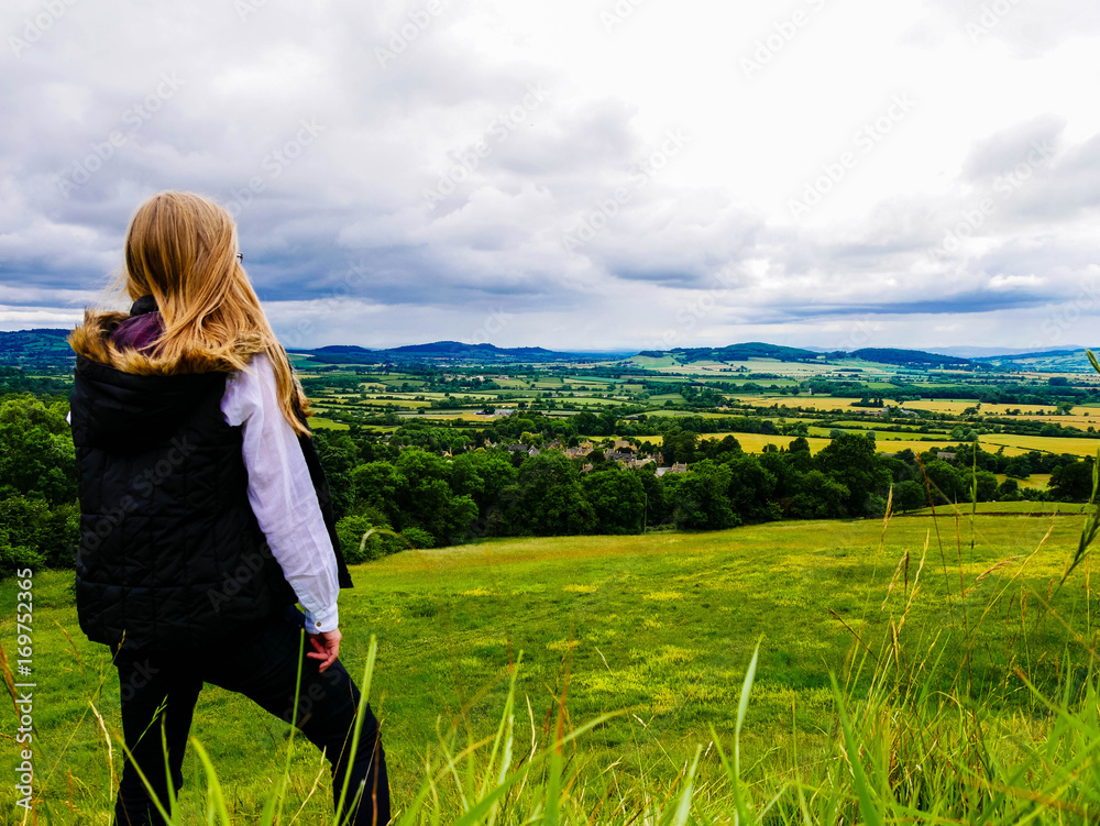 Behind shot of a woman looking out over the Cotswolds countryside