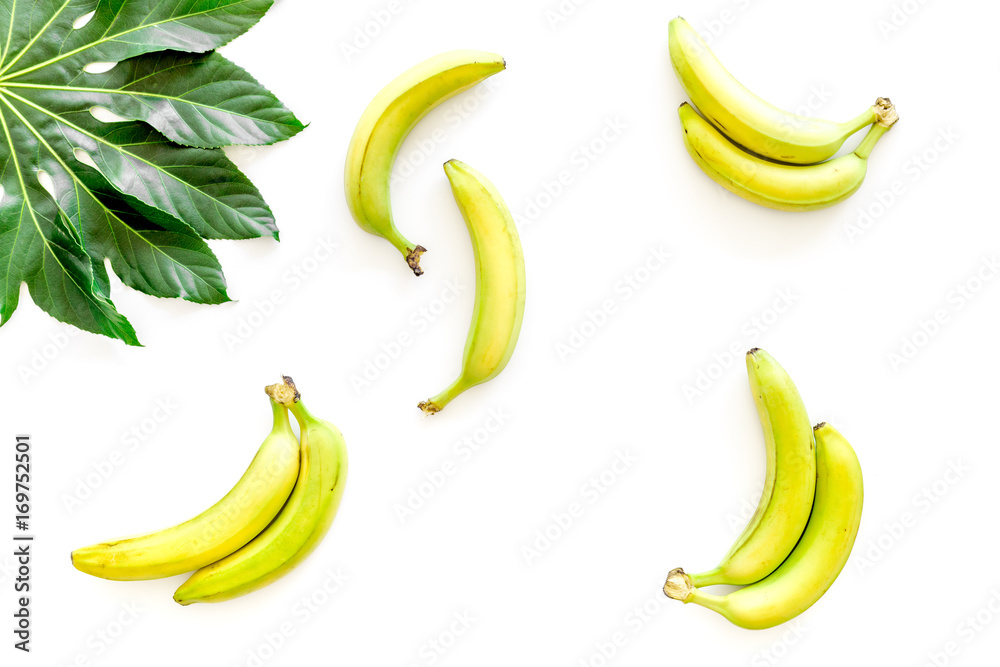 Tropical plants. Huge leaves and bananas on white background top view