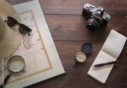 Travel items with map and camera on an old desk