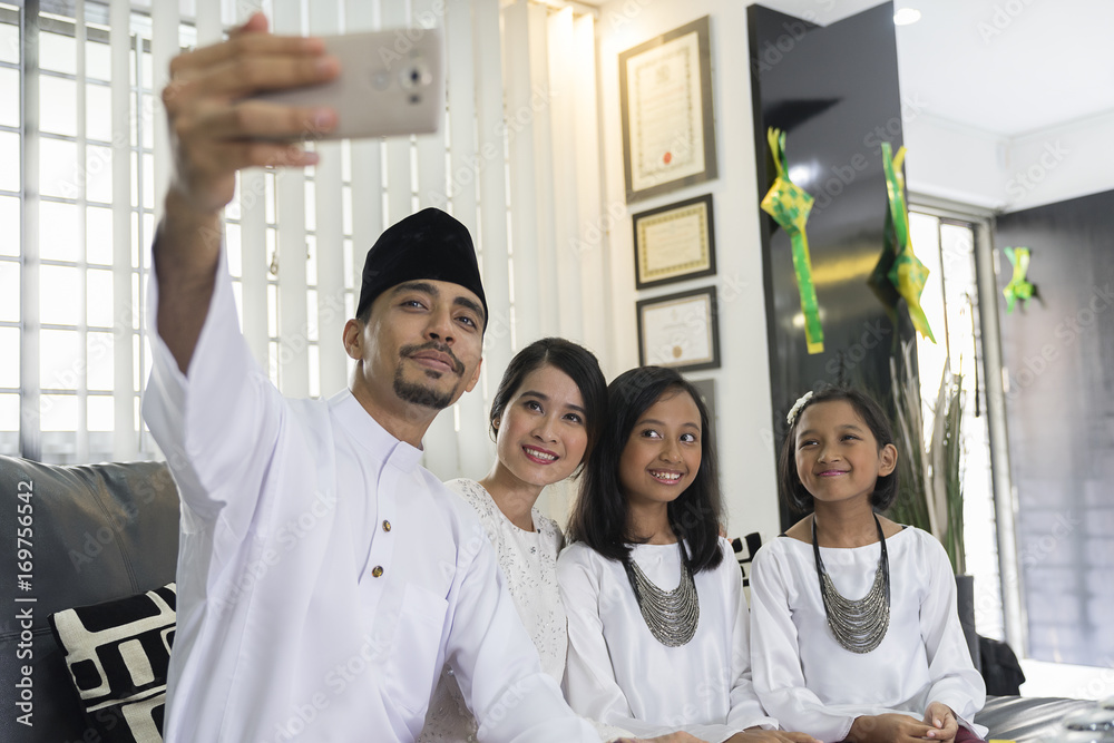 Happy family of four taking a selfie during Hari Raya Stock Photo | Adobe  Stock