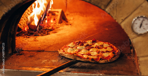 Italian pizza is cooked in a wood-fired oven.