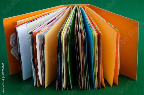 A colorful, handmade junk journal. Made from a recycled box and random paper such as book pages, envelopes and wall paper. Five signatures are stitched in with red thread.