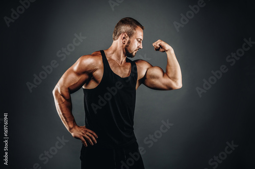 Strong athletic bodybuilder posing with perfect abs, shoulders, biceps, and triceps  chest, personal fitness trainer flexing his muscles © PinkCoffee Studio