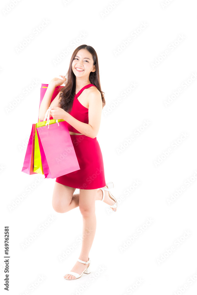 portrait of a happy excited asian woman in red dress standing and holding colorful shopping bags with happy isolated on a white background. portrait of a happy excited asian woman in red dress standing and holding colorful shopping bags with happy isolated on a white background.