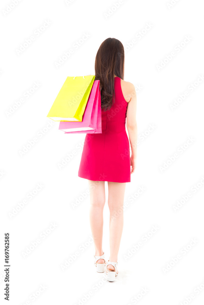 back view of woman with shopping bags . beautiful girl in red dress standing backside view of person and holding paper bag Isolated on white background.