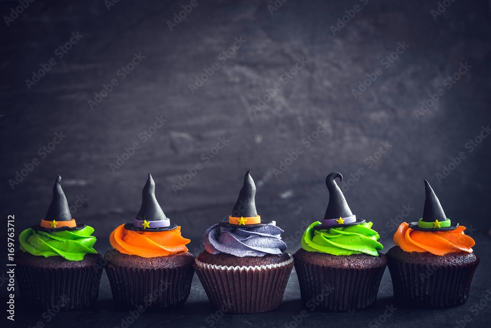 Obraz premium Witch hat cupcakes served on dark background