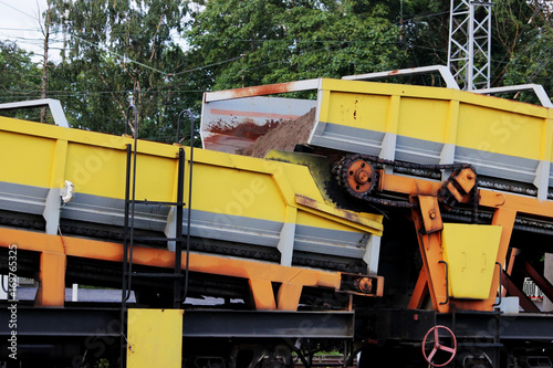 The railroad train platforms with gondola cars that contain a conveyor belt with a rubber-fabric tape for mechanized accumulation, transportation and mechanized unloading of weeds